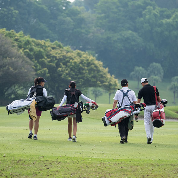 men with golf bags on course